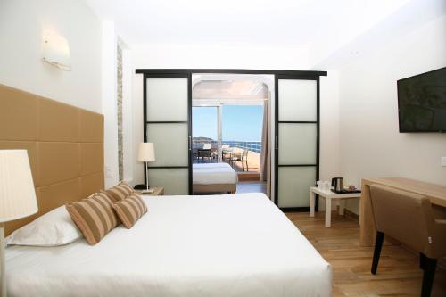 a bedroom with a bed and a view of the ocean at Le Saint Erasme, Hotel Eco Friendly in Calvi