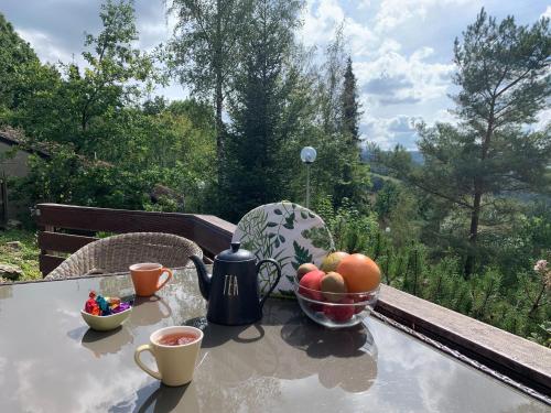 a table with a bowl of fruit and two cups of coffee at Modern Holiday Home in Stavelot with Terrace in Stavelot