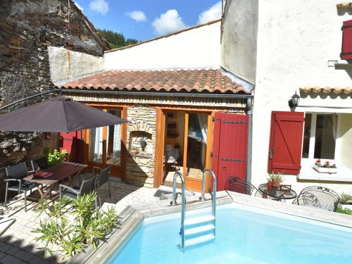 a house with a swimming pool in front of a building at Holiday home with pool in Cuxac Cabard s in Cuxac-Cabardès