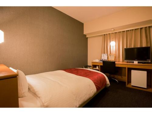 a hotel room with a bed and a desk with a computer at Hotel Taisei Annex - Vacation STAY 05202v in Kagoshima