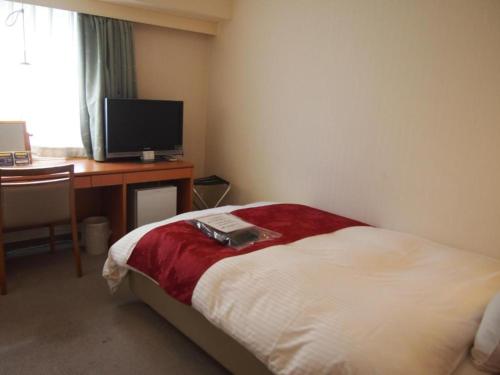 a hotel room with a bed and a desk and a television at Hotel Taisei Annex - Vacation STAY 05207v in Kagoshima