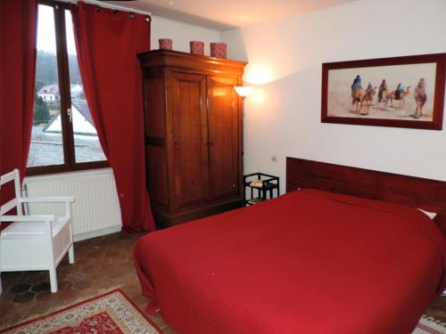 Chambre d'Hôtes Rue des Fougères في لوفييه: غرفة نوم بسرير احمر ونافذة