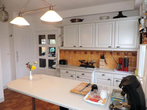 a kitchen with white cabinets and a white counter top at Chambre d'Hôtes Rue des Fougères in Louviers