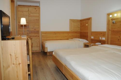 En eller flere senge i et værelse på Hotel Garni Arnica ***S