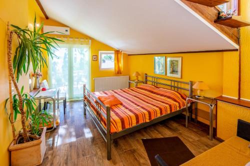 um quarto com paredes amarelas e uma cama num quarto em Apartments SENKA em Dramalj