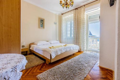 - une chambre avec un lit et une grande fenêtre dans l'établissement Rooms CICO, à Crikvenica