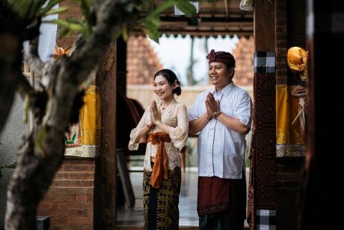 un homme et une femme debout à la porte dans l'établissement PNB Bali Villas, à Canggu