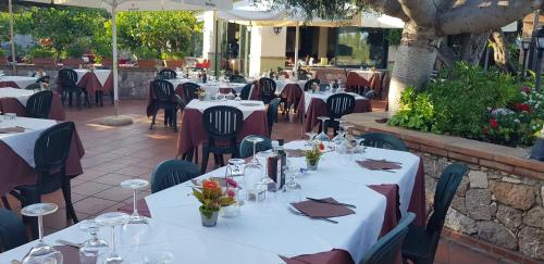 a restaurant with tables and chairs with white table cloth at Villa Antonino in Giardini Naxos