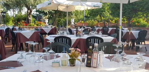 a restaurant with tables and chairs with wine bottles at Villa Antonino in Giardini Naxos