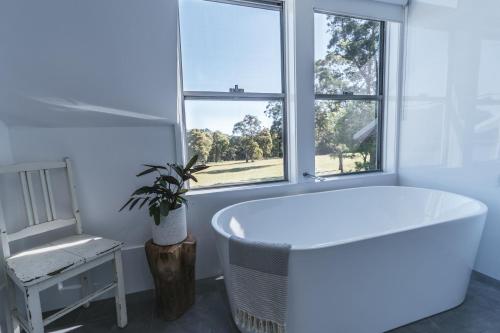 a white bath tub in a room with a window at Worrowing Jervis Bay in Huskisson