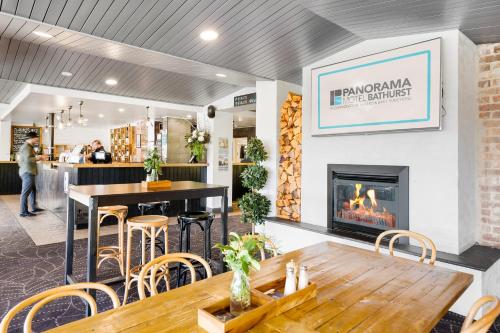 a restaurant with a fireplace and a table and chairs at Panorama Bathurst in Bathurst