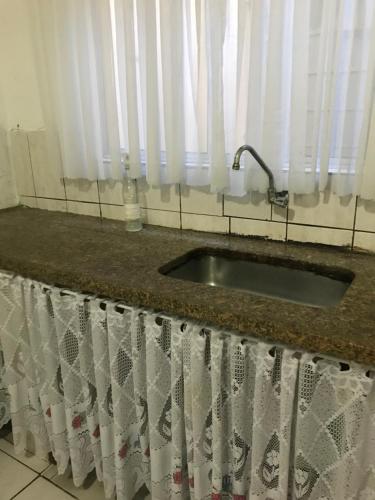 fregadero de cocina con cortina de ducha y ventana en Pousada Vera, en São Paulo