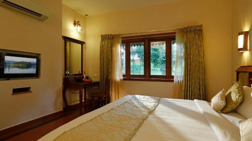 a bedroom with a white bed and a window at Greenwoods Resort, Thekkady in Thekkady
