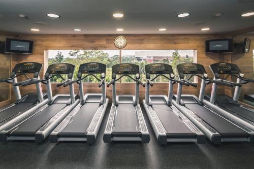 a gym with a row of treadmills and a clock at Presidente InterContinental Mexico City by IHG in Mexico City