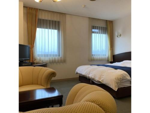 a hotel room with two beds and a desk and chairs at Shobara Grand Hotel - Vacation STAY 06902v in Shōbara