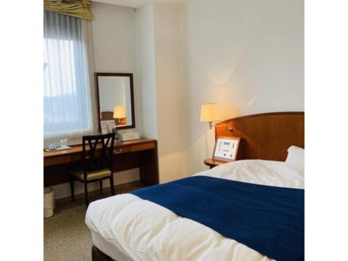 a bedroom with a bed and a desk and a chair at Shobara Grand Hotel - Vacation STAY 06899v in Shōbara