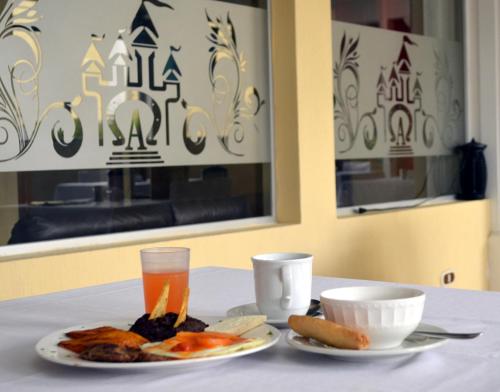 a table with two plates of food and a drink at Hotel y Restaurante Castillo de los Altos in Quetzaltenango