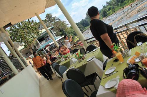 a group of people sitting at tables on a cruise ship at Hotel Pinnalanda in Pinnawala
