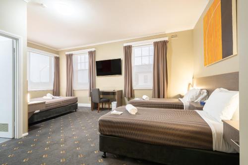 德文港的住宿－The Formby Hotel，酒店客房配有两张床和一张书桌