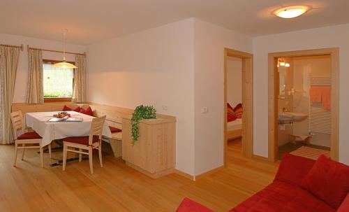 a living room and dining room with a table and a couch at Ferienwohnungen Bulandhof in Valdaora