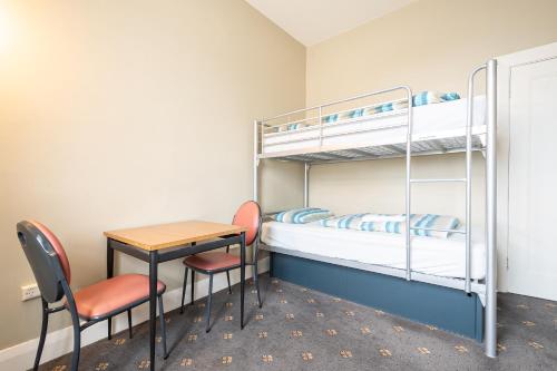 a room with bunk beds and a table and a desk at The Formby Hotel in Devonport