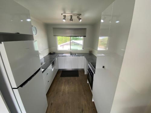 a kitchen with white cabinets and a window at Residential two-bedroom unit on The Strand, self-check in, Wi-fi in Townsville