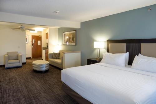 a hotel room with a large bed and a chair at Holiday Inn Express Hotel & Suites-Saint Joseph by IHG in Saint Joseph