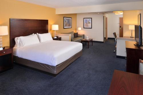 a hotel room with a large bed and a living room at Holiday Inn Express Hotel & Suites-Saint Joseph by IHG in Saint Joseph