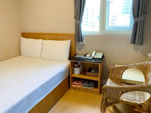 a small room with a bed and a telephone at XDZ Hotel in Taipei