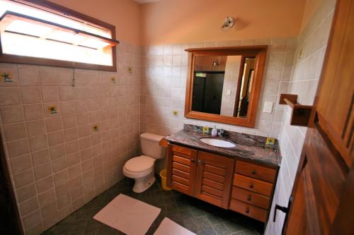 a bathroom with a toilet and a sink and a mirror at Feriasmares in Ilhéus