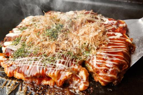 a piece of meat covered in sauce and cheese at Hotel -ASIATO- in Osaka