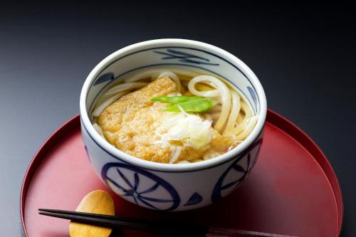 a cup of noodle soup on a red plate at Hotel -ASIATO- in Osaka