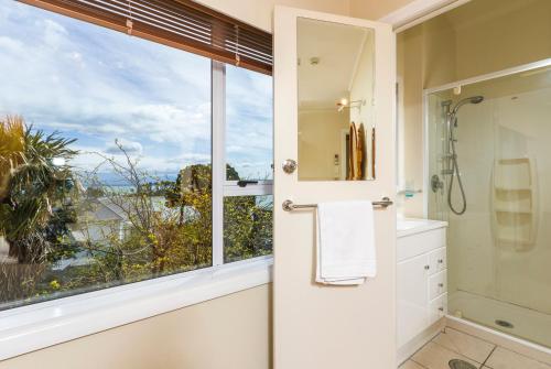 a bathroom with a shower and a large window at Kimberley Three - Nelson Waterfront Penthouse in Nelson