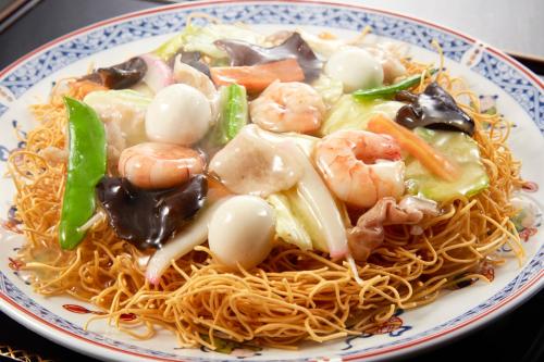 a plate of noodles with shrimp and vegetables on it at Tabist Sasebo Palace Hotel in Sasebo