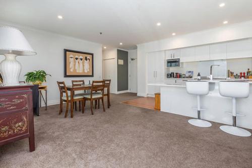 a kitchen and dining room with a table and chairs at QV Spacious Apt on the Wharf with Wifi (797) in Auckland