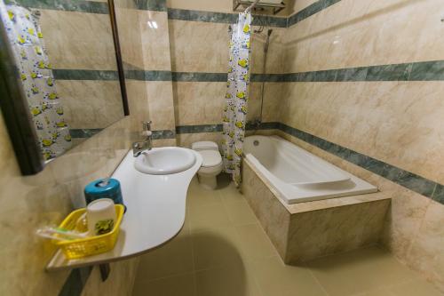a bathroom with a sink and a tub and a toilet at Star Hotel in Battambang