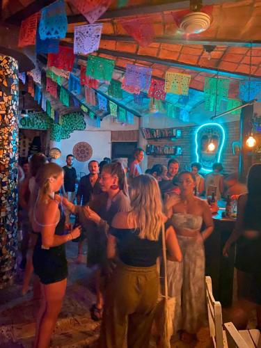 a group of people standing in a bar at La Redonda Sayulita Hostal in Sayulita