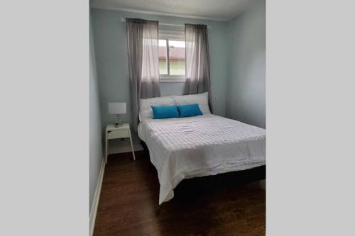 a small bedroom with a bed with blue pillows at Cottage with River Front & minutes away from Beach in Wasaga Beach