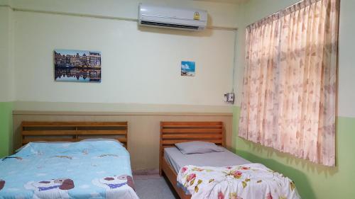 1 Schlafzimmer mit 2 Betten und einem Fenster in der Unterkunft Sataya Apartment in Maha Sarakham