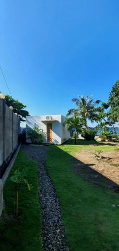 a house with a yard with grass and a building at A Villas Resort & Restaurant in Zamboanguita