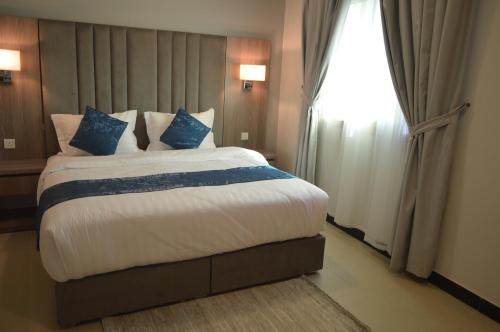 a bedroom with a large bed and a window at Terrace View Serviced Apartments 3 in Dammam