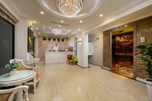 a large room with a counter and a chef in a kitchen at C'Bon Hotel Do Quang in Hanoi