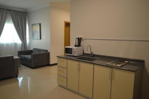 a kitchen with a sink and a microwave on a counter at Terrace View Serviced Apartments 3 in Dammam