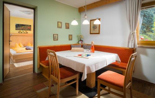 a dining room with a white table and chairs at Ferienhaus Sonnenhang in Matrei in Osttirol
