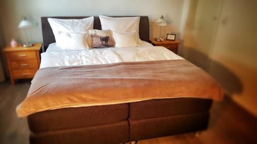 a bedroom with a large bed with white sheets and pillows at Ferienhaus Linder in Fischen