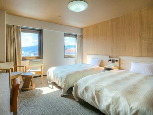 a hotel room with two beds and two windows at Maizuru Grand Hotel in Maizuru