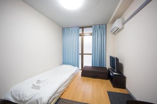 a small room with a bed and a television at 102 Uzumasa Arashiyama 2free Bike Wifi in Sagano