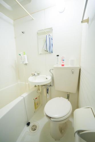 a white bathroom with a toilet and a sink at 102 Uzumasa Arashiyama 2free Bike Wifi in Sagano