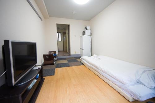 a room with a bed and a flat screen tv at 102 Uzumasa Arashiyama 2free Bike Wifi in Sagano