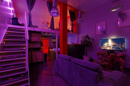 ein lila Wohnzimmer mit Sofa und Treppe in der Unterkunft Romance Spa lofts haut de gamme avec sauna in Le Havre